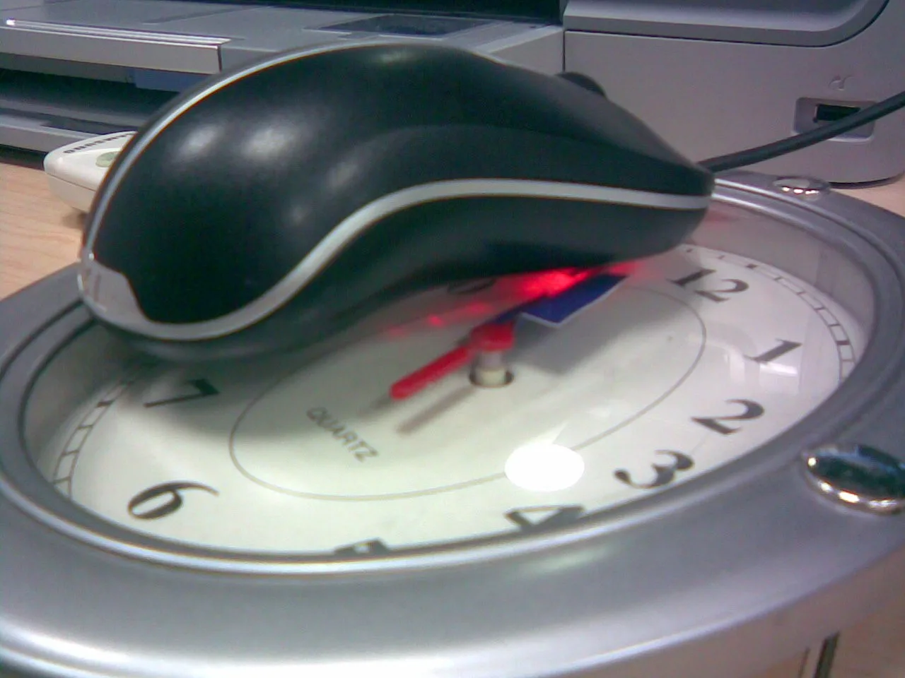 Zbliżenie na myszkę na zegarze — widoczny sekundnik z przyklejoną kartką